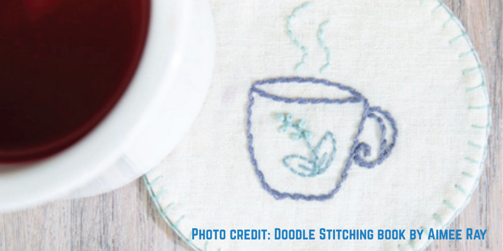 A stitched cup with a little plant