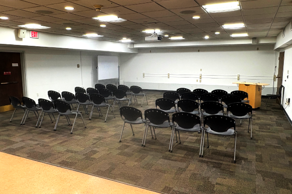 white room with four rows of four chairs separated by an aisle