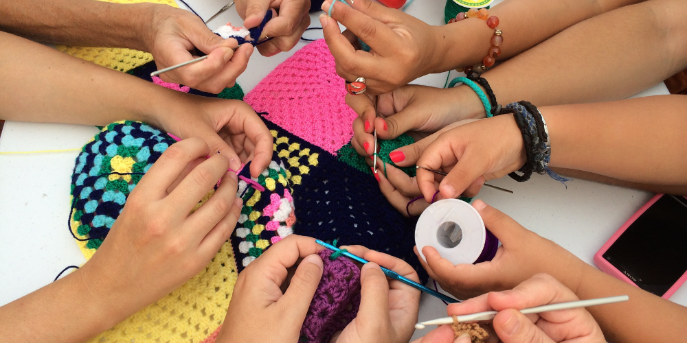 Arms in a circle, surrounding misc craft supplies