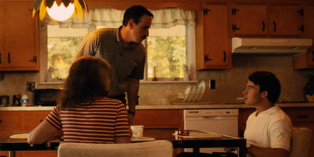 Still from the film Danbury, a women and man sitting at a kitchen table with one man standing.